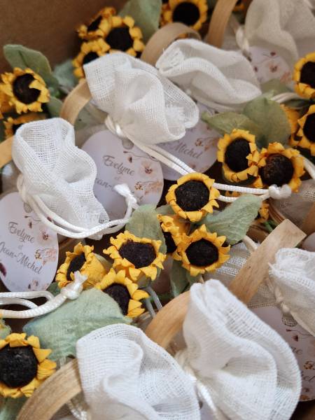 des fleurs et des pochons en lin blanc, le tout dans un petit panier en osier - Dragées Rosière
